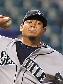 Jogador de beisebol com uniforme cinza e boné azul marinho